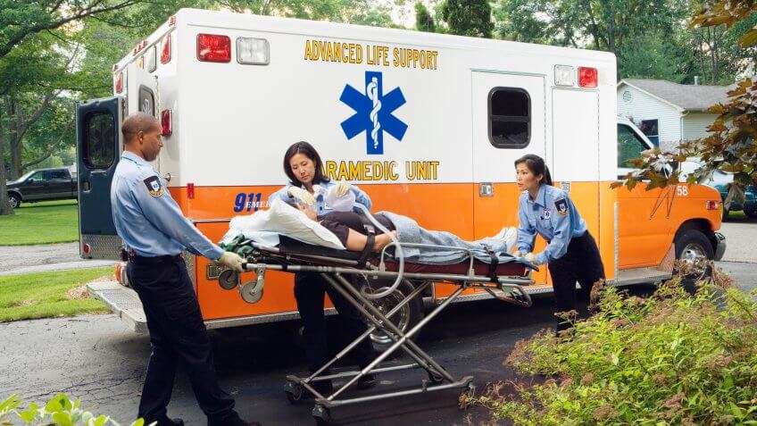 Paramedics putting woman into ambulance.