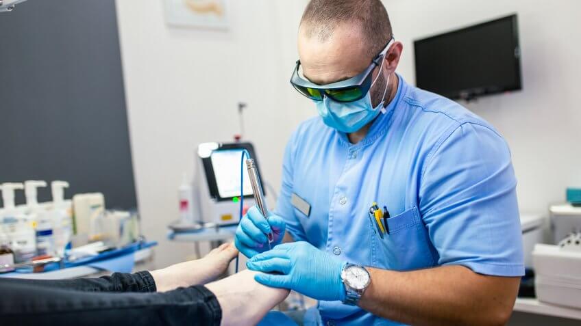 Toenail fungus treatment with foot laser at laser nail therapy clinic.