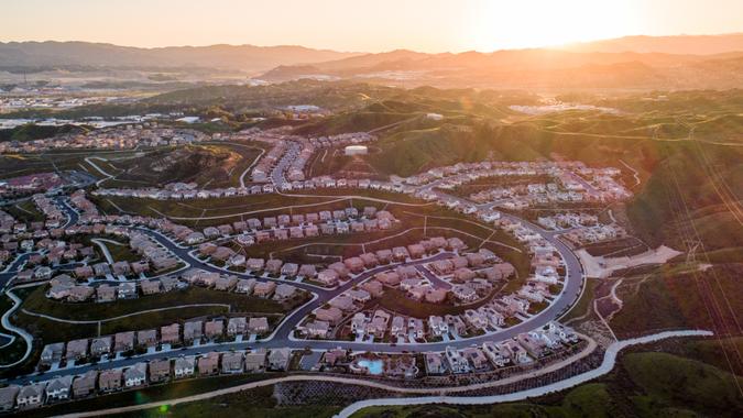 Aerial of tract housing and American suburban development in Southern California at sunset.