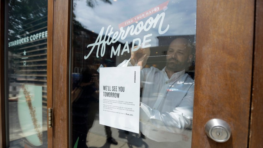 Mandatory Credit: Photo by Matt Slocum/AP/Shutterstock (9696052a)A man tapes a sign to a door at a Starbucks Coffee shop, in Philadelphia.