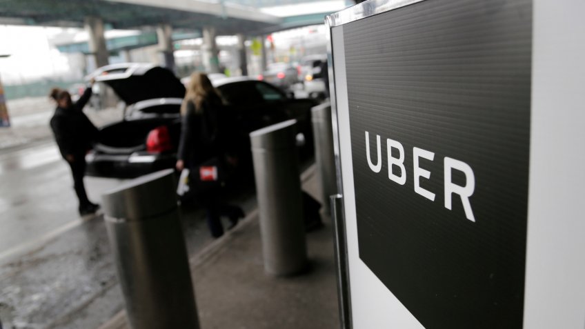 Mandatory Credit: Photo by AP/Shutterstock (8523655a)A sign marks a pick-up point for the Uber car service at LaGuardia Airport in New York.