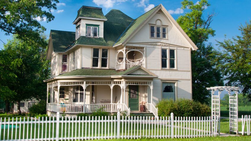 A beautiful and well maintained two story country home with white picket fence stands on the edge of a small rural town in Wisconsin.