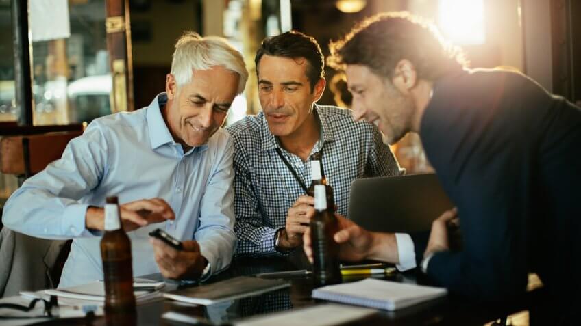 Close up of a group of business people having a drink after work.
