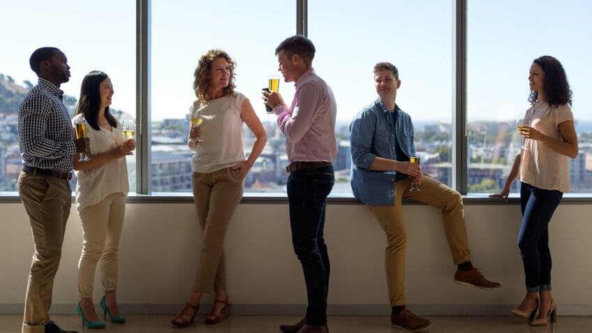 Full length of business people having drinks at window.