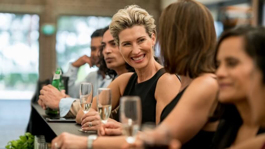 Happy group of business people having drinks at a bar and laughing â lifestyle concepts.