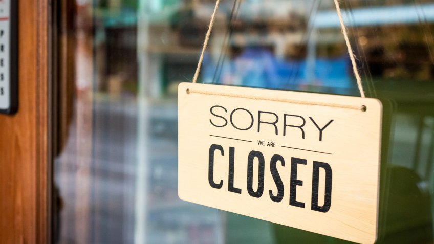 Sorry we are closed sign board hanging on a door of cafe.