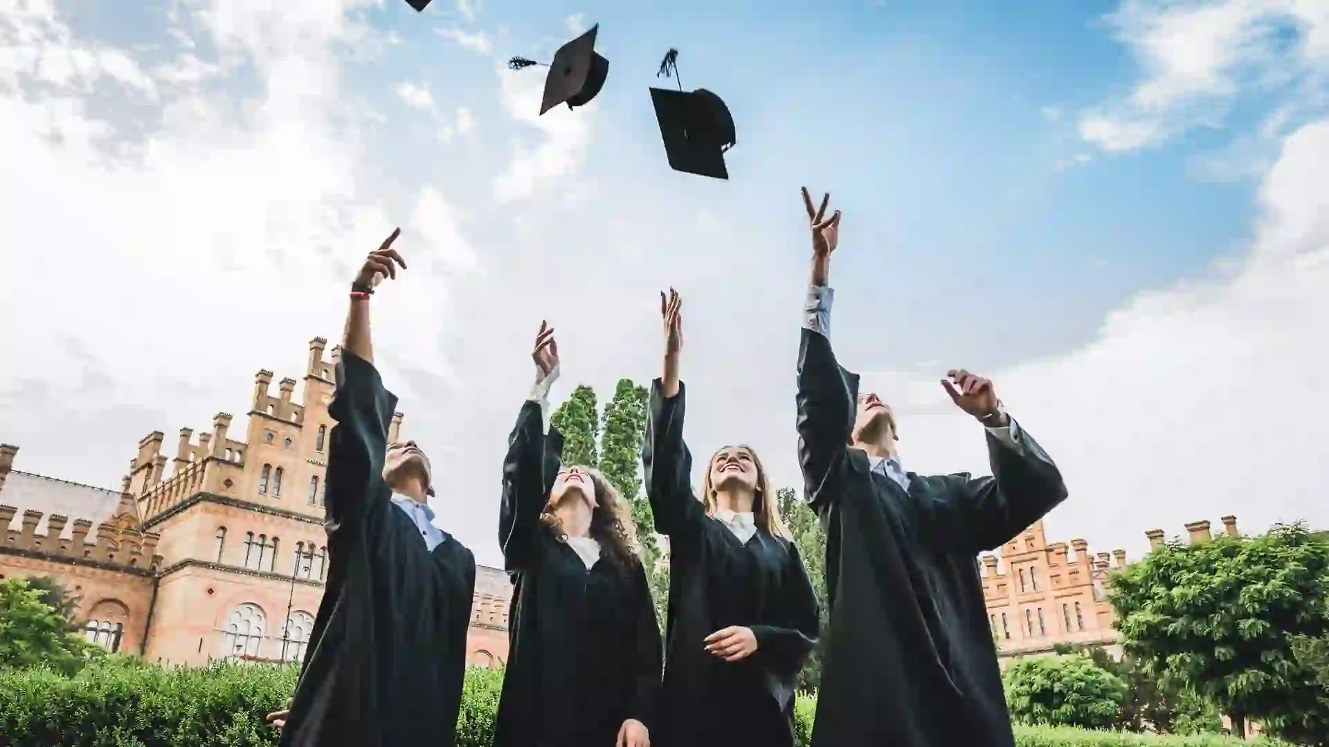 We've finally graduated! Graduates near university are throwing up hats in the air.