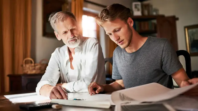 Shot of two men working on a project together at home.