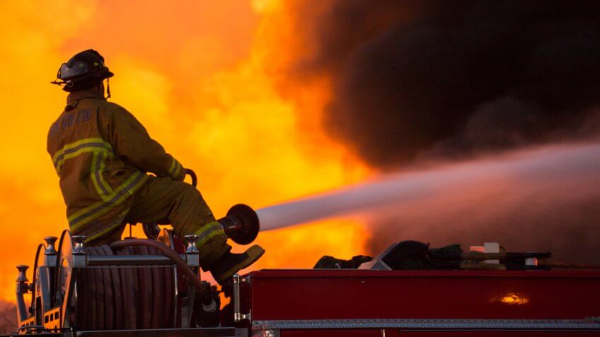 Santa Fe Springs, California - May 29, 2014: Firefighters try to douse the flames of a recycling sorting facility on fire.