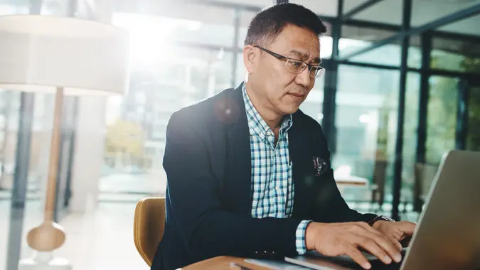 Shot of a mature businessman working on a laptop in an office.