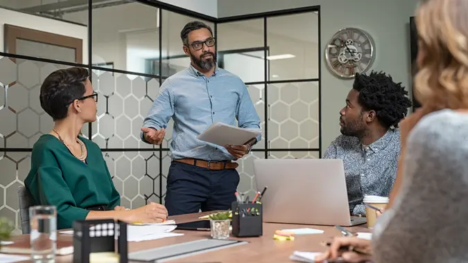 Confident mature businessman giving a presentation to his team in office.