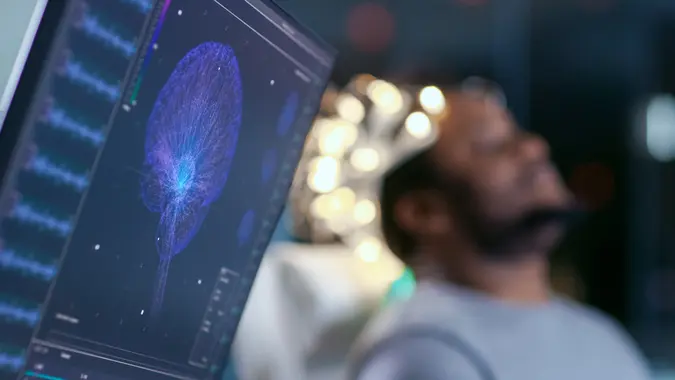 Monitors Show EEG Reading and Graphical Brain Model.