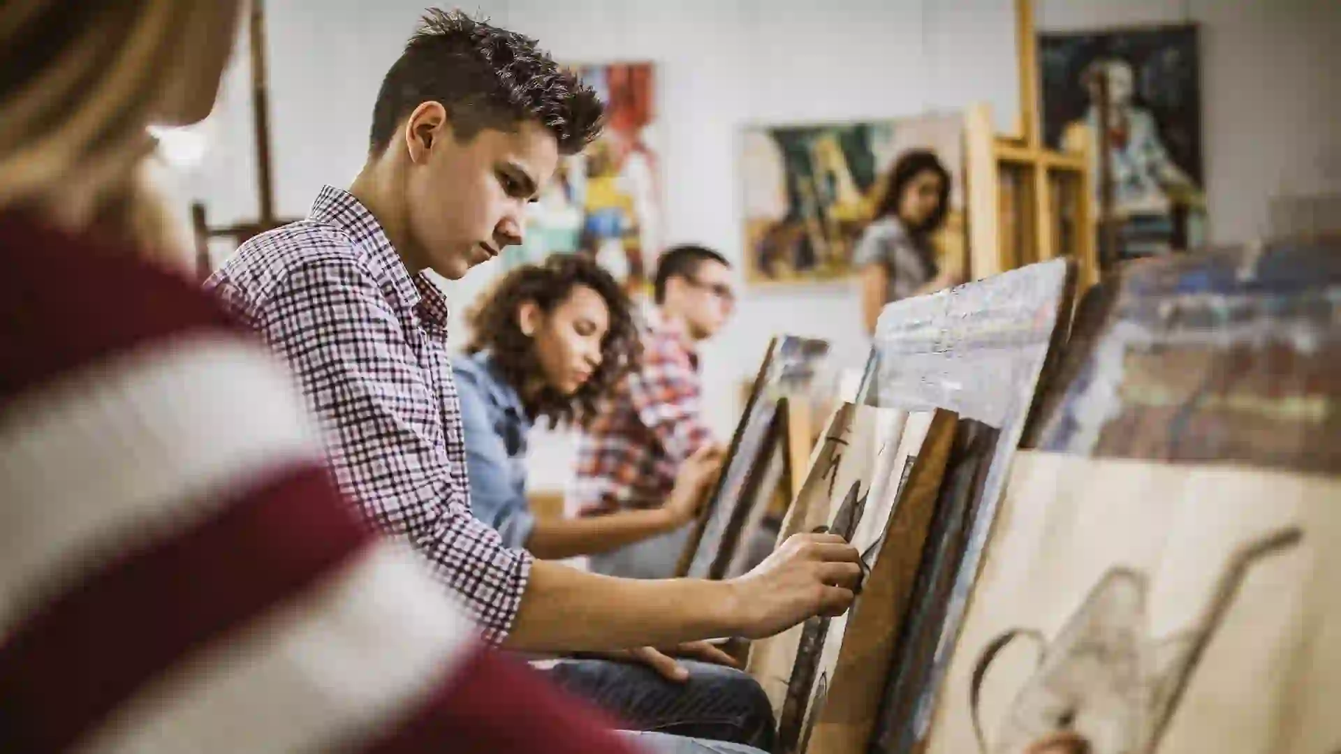 Group of students drawing their paintings on a class at art studio.