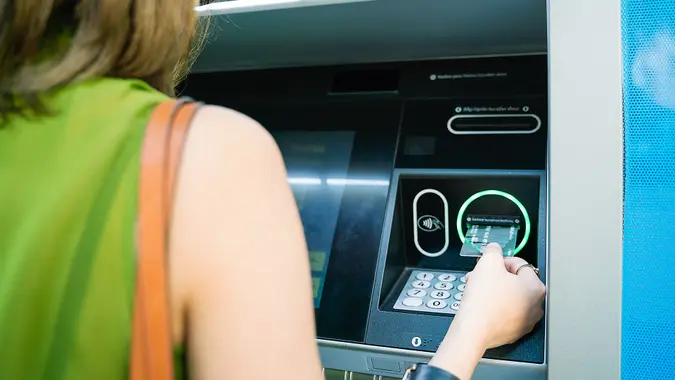 Woman inserting ATM credit card.