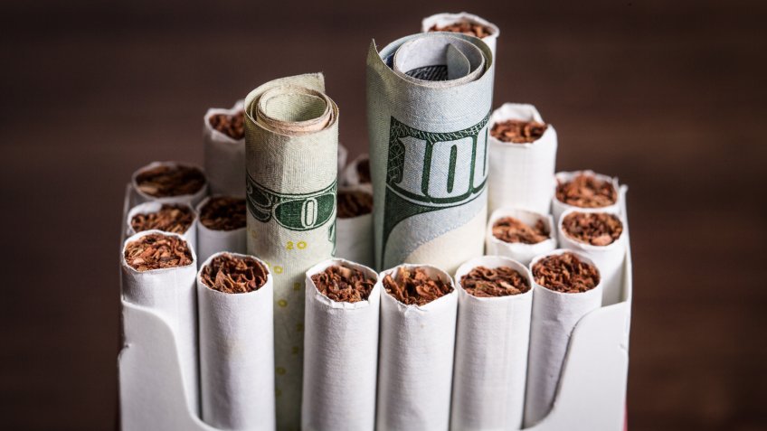 Cigarette concept with money cash replacing cigars.