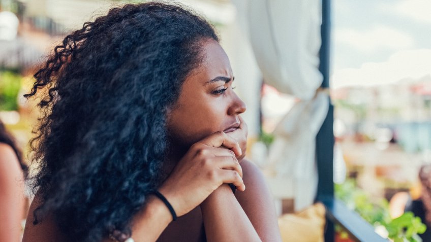 Unhappy woman on a vacation staring into the distance.