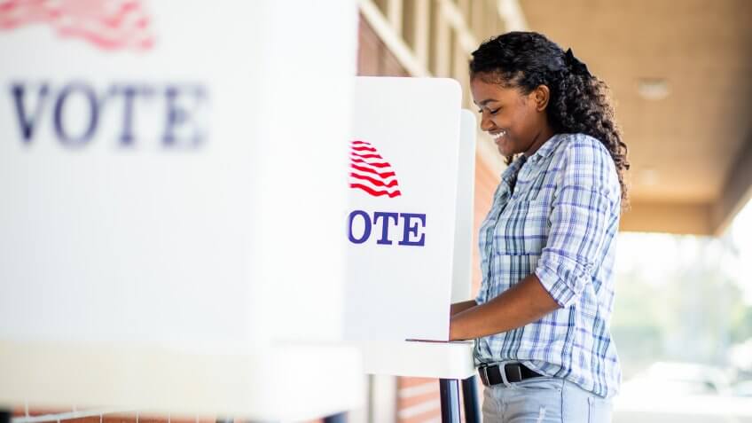 A young black girl voting on election day.
