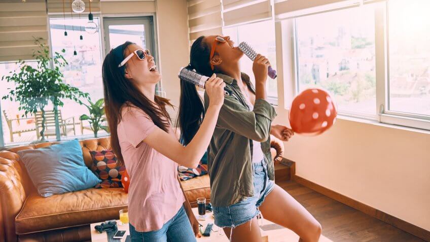 two cheerful friends singing and having fun.