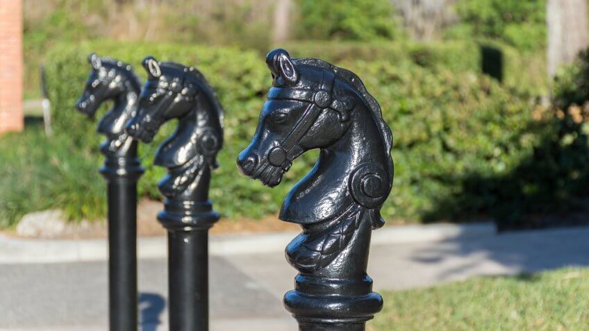 Black painted bollard shaped as a horse head.