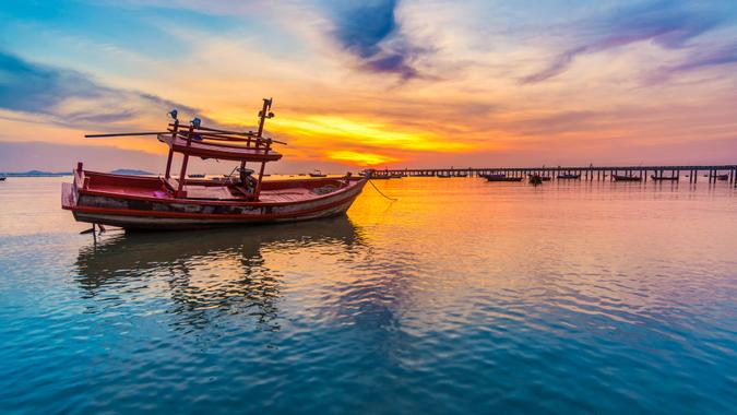 sunset on the sea with a boat at Bangpra beach chonburi,thailand.