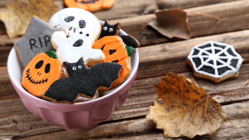 Fresh halloween gingerbread cookies on brown wooden table.