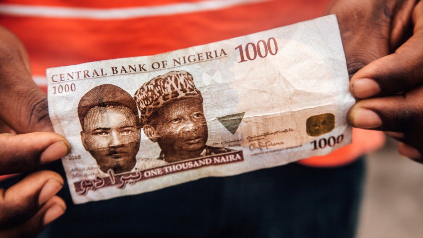 African man holding money - Nigerian Naira.