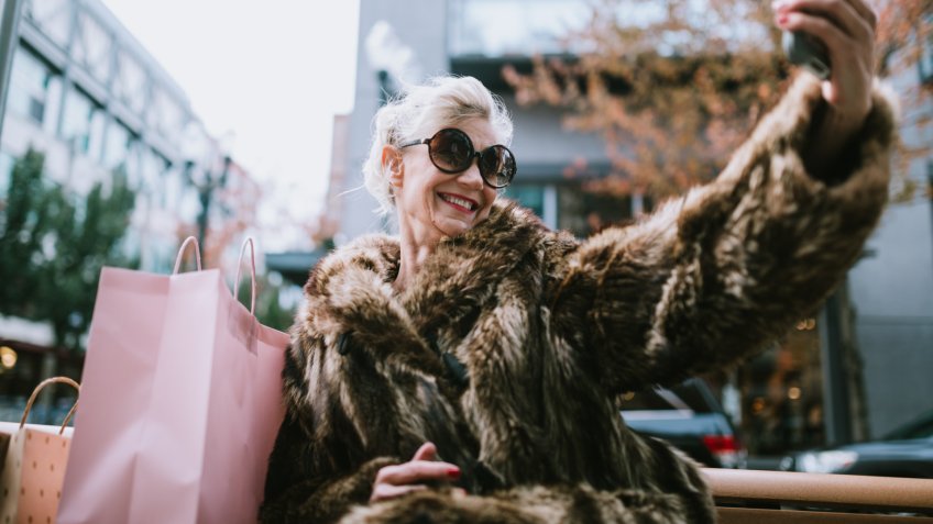 A fun and cheerful senior woman enjoys a day out on the town in the city of Portland, Oregon.