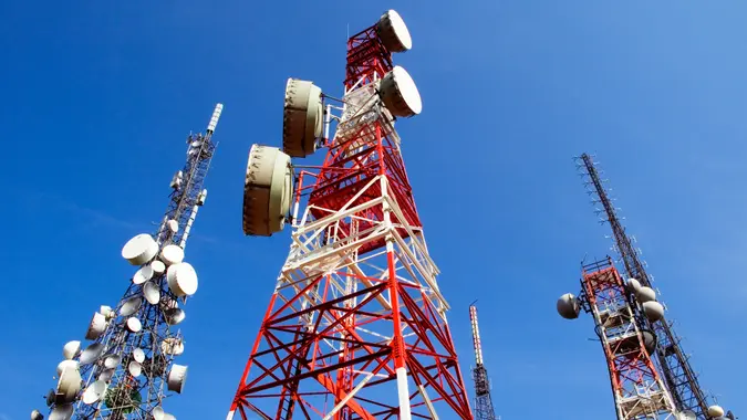 Telecommunications towers on blue sky, a red and white, the other white, antennas for television, radio, and mobile phones.