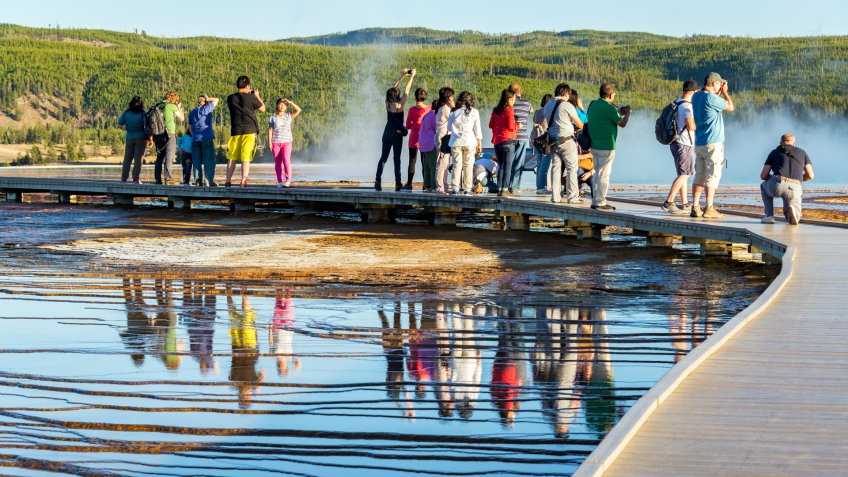 YELLOWSTONE NATIONAL PARK, WY - SEPTEMBER 11: Crowd of tourists take pictures of Grand Prismatic Spring in Yellowstone National Park, WY on September 11, 2015.