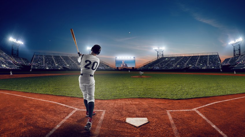 Baseball player at professional baseball stadium in evening during a game.