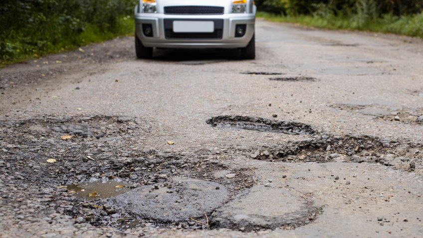 car driving over pot holes