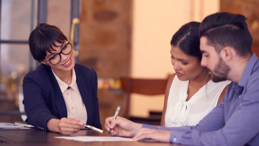 Shot of a young couple meeting with a financial planner in an office.