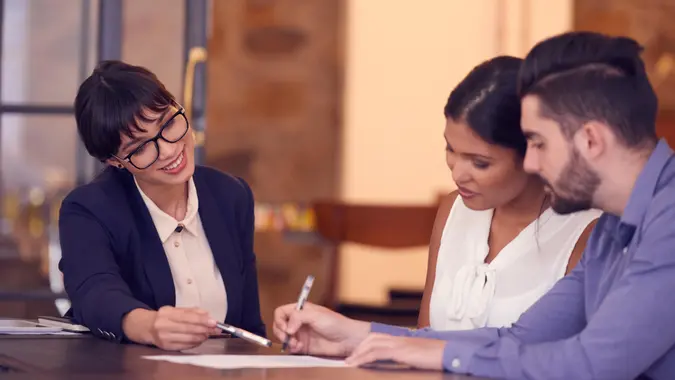 Shot of a young couple meeting with a financial planner in an office.
