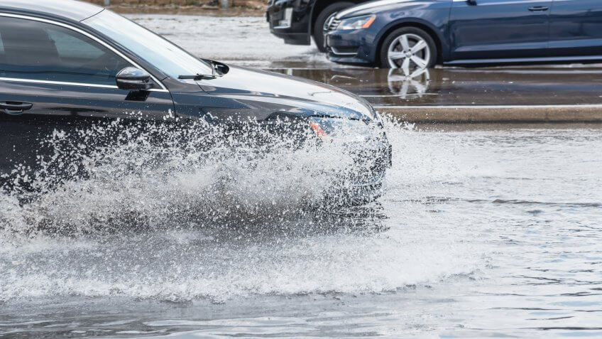 cars driving through flooded street