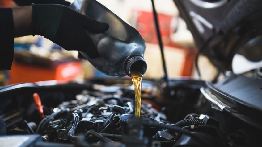 Close up hands of unrecognizable mechanic doing car service and maintenance.