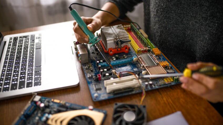 Close up of a woman hands repairing computer.