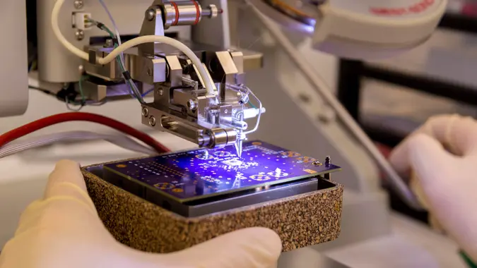 This shot shows a wire bonder being used to attach a silicon chip to a printed circuit board.