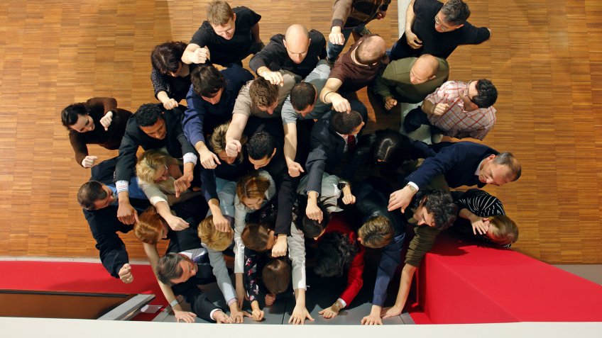 "Large group of people trying to get through closed doors.