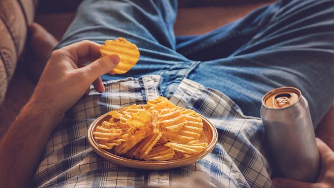 eating chips and junk food on the couch