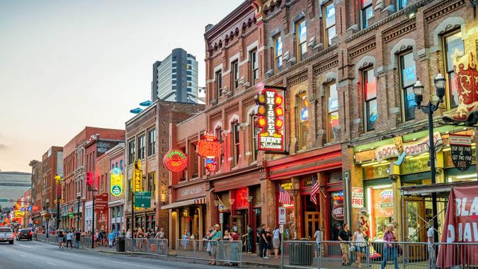 People enjoy a pleasant evening in the Broadway pub district, downtown Nashville, Tennessee, USA at twilight.