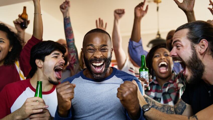 Friends cheering sport at bar together.