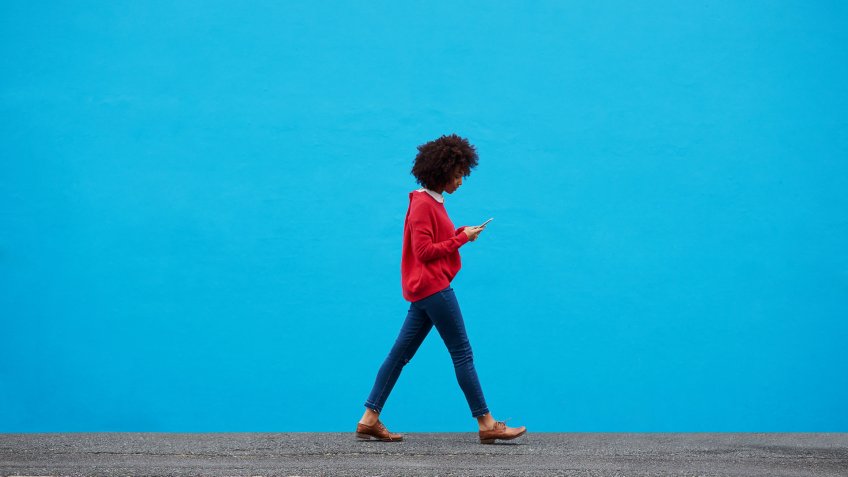 Shot of a fashionable young woman using her cellphone while walking through the city.