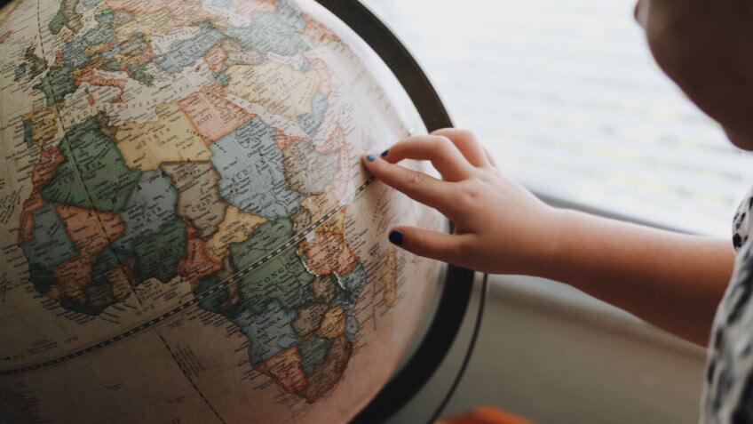 child pointing finger at globe