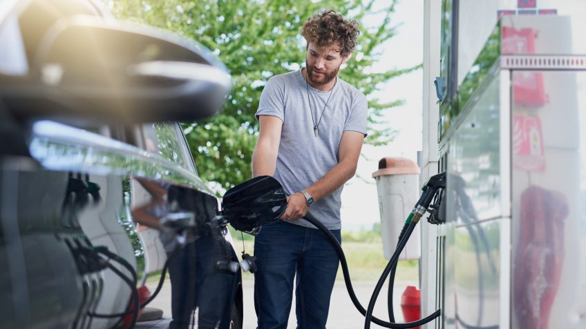 Cropped shot of a handsome young man refuelling his car at a gas station.