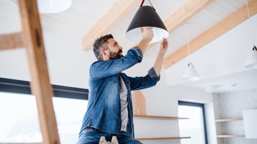 A cheerful mature man furnishing new house, a new home concept.