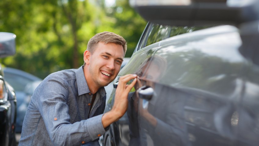 man checking out used car trim