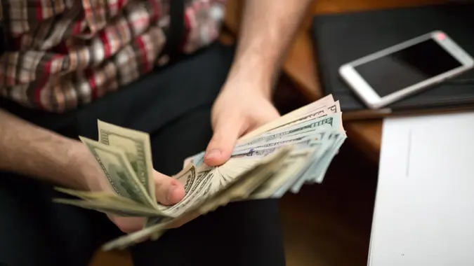 man counting usa dollars, focus on banknotes.