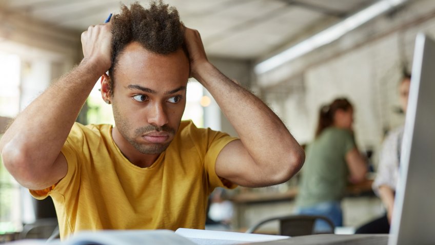 man panicking looking at computer