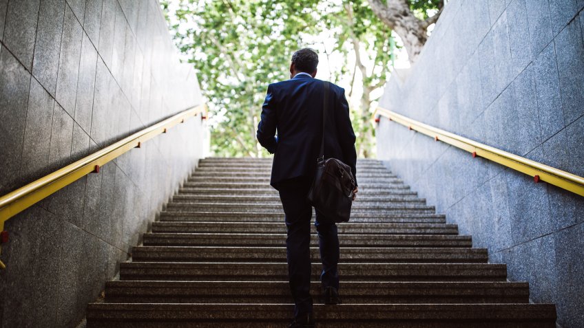 Pedestrian Businessman Walking Out Of Metro Up Stairs On Sunny Morning.