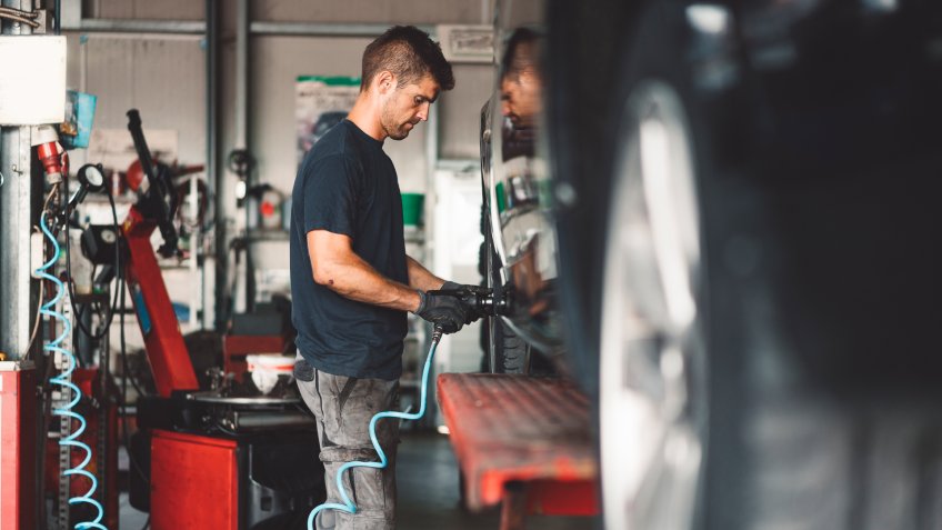 Vulcaniser work-shop, changing tires on a car.